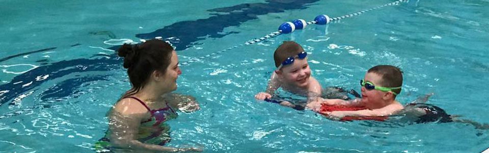 Kids swimming with instructor